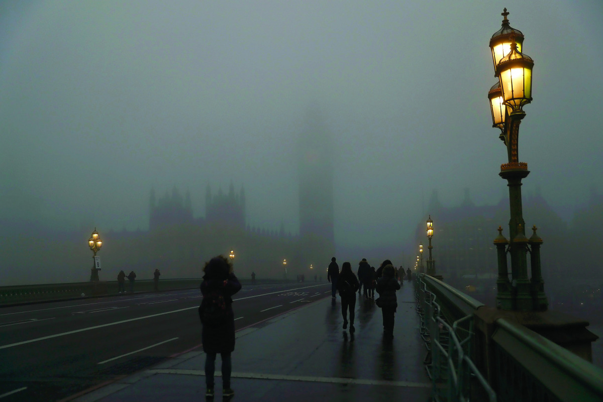 Pedestrians cross Westminster Bridge on a foggy morning in central London, yesterday.