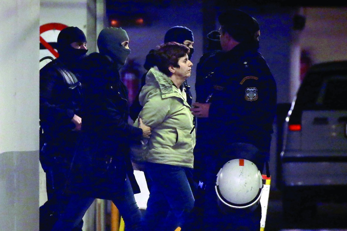 Member of the militant Revolutionary Struggle group Paula Roupa (centre) is escorted by anti-terrorist police officers during her transfer in a court in Athens, yesterday.