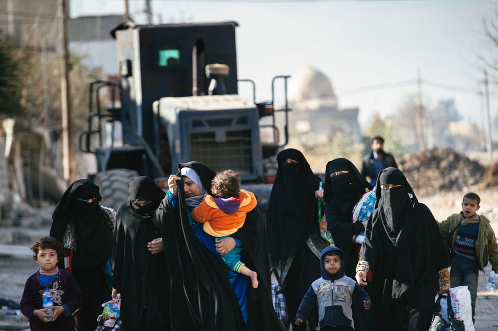 Iraqi women and children are pictured in Mosul's al-Sahiroun neighbourhood on January 12, 2017, as they flee their homes during a military operation by Iraqi security forces against IS militants.  AFP / Dimitar DILKOFF
