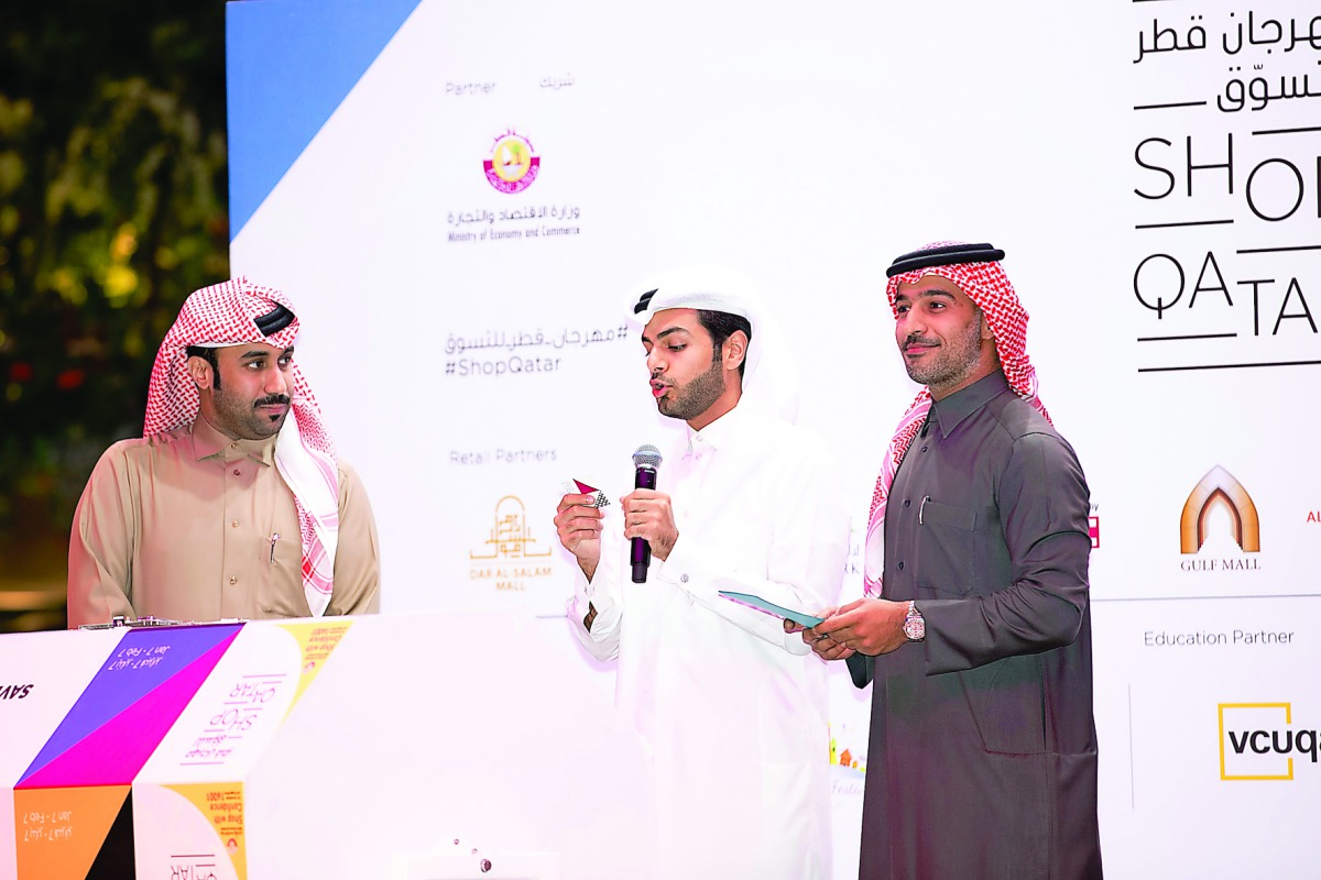 Qatari social media influencer, Abdulaziz Al Ajeel, announces the winners as Hamad Al Khaja of QTA (right) and Jassim Al Kuwari of the Ministry of Economy and Commerce look on during the second weekly raffle draw at Mall of Qatar.