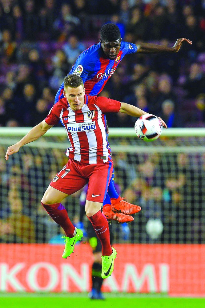Barcelona defender Samuel Umtiti vies with Atletico Madrid's forward Kevin Gameiro during the Spanish Copa del Rey semi-final second leg match at the Camp Nou Stadium in Barcelona on Thursday.