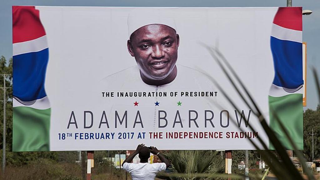 A man takes a photo of a billboard prepared for an invitation of the event which held at Independence Stadium on February 18, for Gambia's president Adama Barrow, at Banjul International Airport in Banjul, Gambia on January 26, 2017. ( Xaume Olleros - Ana