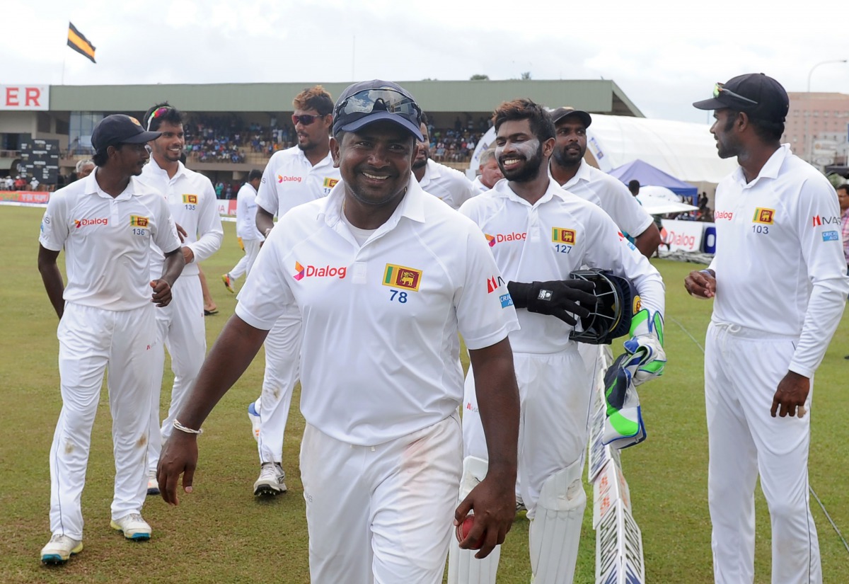Sri Lankan cricket captain Rangana Herath (C) celebrates with his teammates after victory in the opening Test match between Sri Lanka and Bangladesh at the Galle International Cricket Stadium in Galle on March 11, 2017. (AFP / LAKRUWAN WANNIARACHCHI)