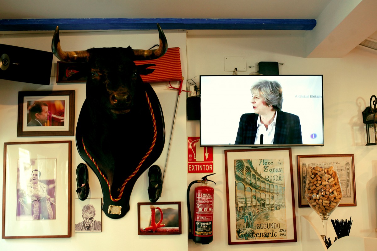 FILE PHOTO: Britain's Prime Minister Theresa May is seen on a television screen next to a mounted bull's head during a prime time news broadcast at a restaurant in Fuengirola, southern Spain, delivering her keynote speech on Brexit at Lancaster House in L