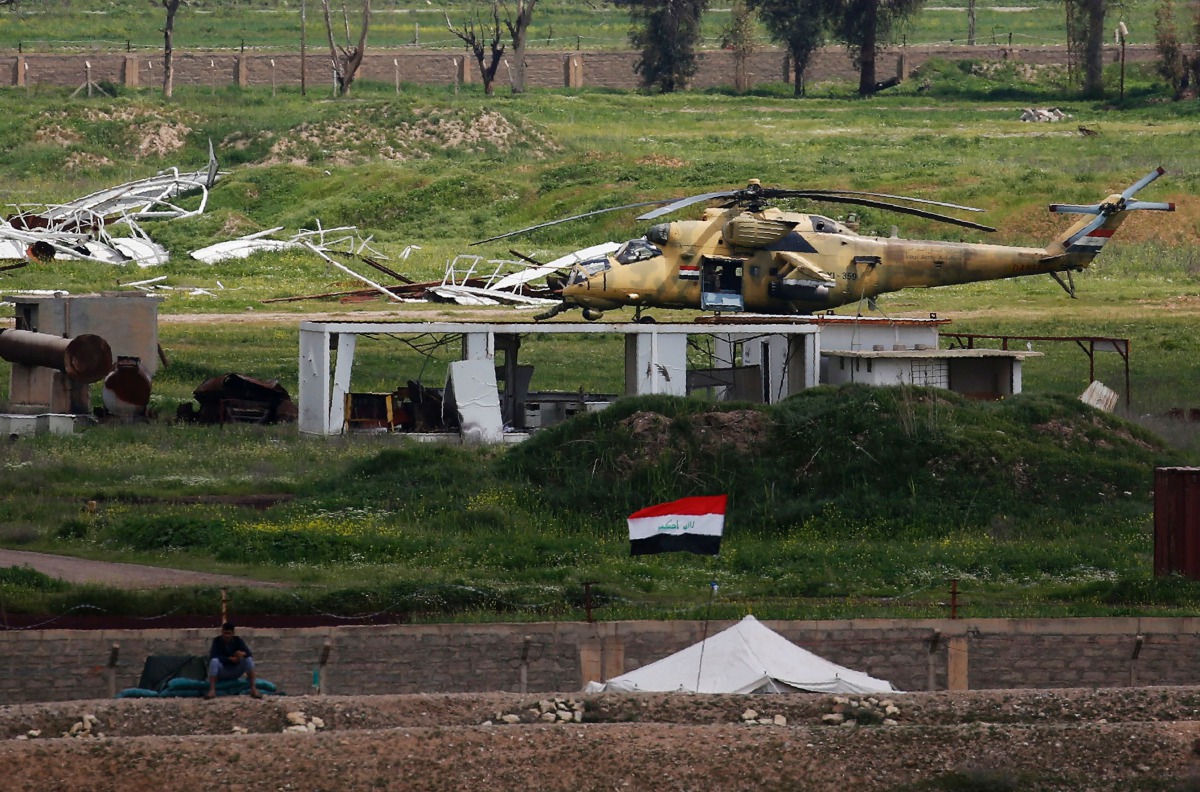 An Iraqi army helicopter sits in a field on the outskirts of western Mosul on April 3, 2017, during an offensive to retake the city from Islamic State (IS) group fighters. AFP / Ahmad Gharabli