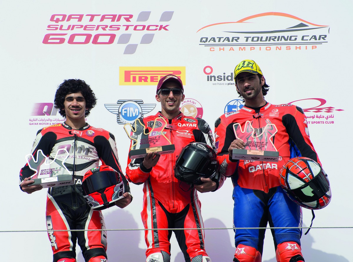 Nasser Al Malki (centre), Abdulla Al Qubaisi (left) and Ali Al Shammari pose after the second race at the Losail International Circuit.   