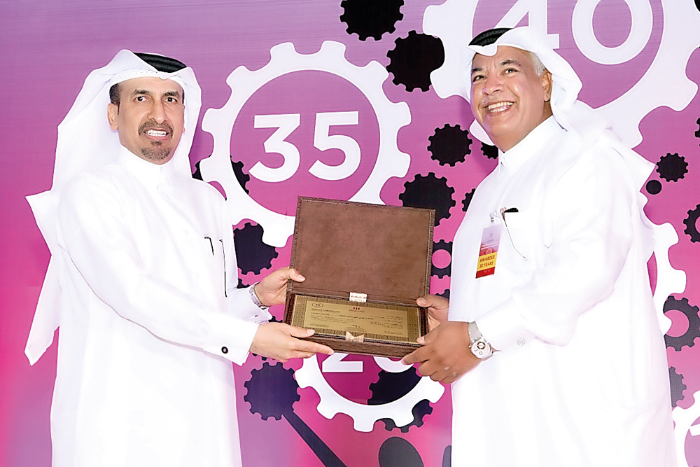 Ali bin Hassan Al-Muraikhi (left), Qatar Steel's Managing Director honouring a long-serving employee at the event.