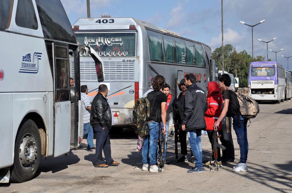 Syrian opposition fighters and their families arrive at a checkpoint manned by regime forces ahead of their evacuation from Waer neighbourhood, the last opposition-held district in the central city of Homs, on May 20, 2017. / AFP / STRINGER

