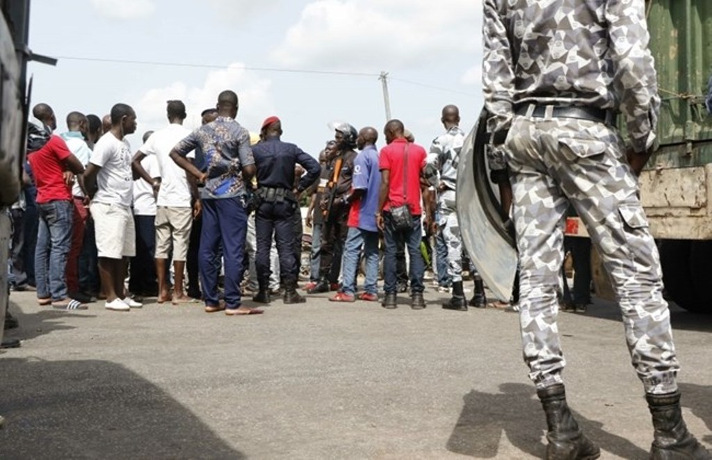 Disgruntled former rebels demanding government compensation payments speak to gendaremes and police officers as they block a road on May 22, 2017 into Ivory Coast's second biggest city, Bouake. / AFP / STR.