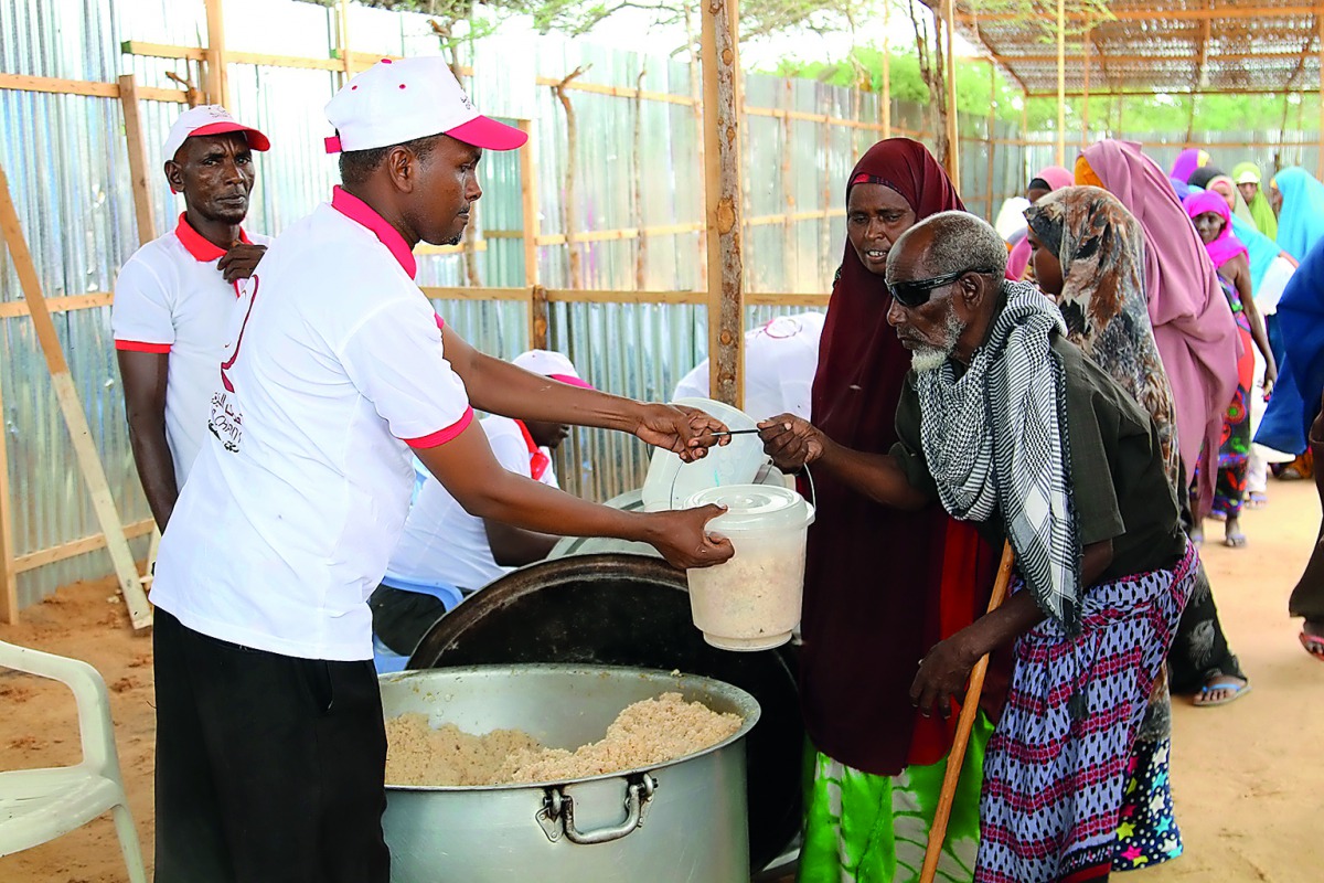 A Qatar Charity volunteer handing over food to a needy in Somalia. 