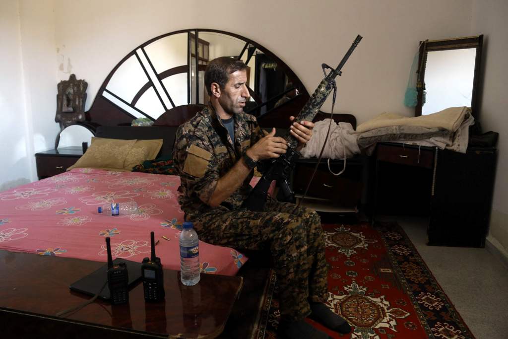 A member of the Kurdish People's Protection Units (YPG) sits in a bedroom as he holds a position in the al-Dariya neigbourhood of the Syrian city of Raqa, on June 18, 2017, during an offensive by US-backed fighters to retake the Islamic State (IS) group b
