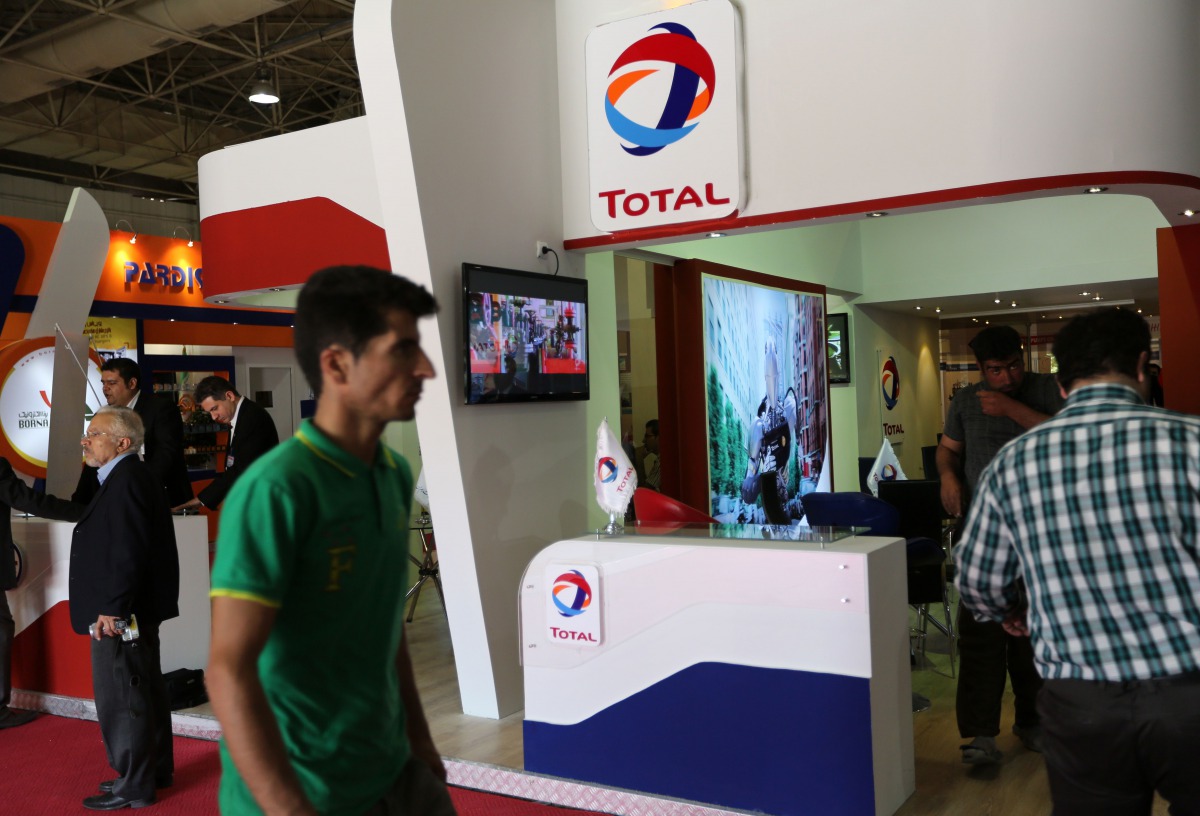 This file photo taken on May 06, 2015 shows people walking past the stand of French oil and gas company Total during Iran's annual International Oil, Gas, Refining & Petrochemical Exhibition in Tehran. (AFP / ATTA KENARE)