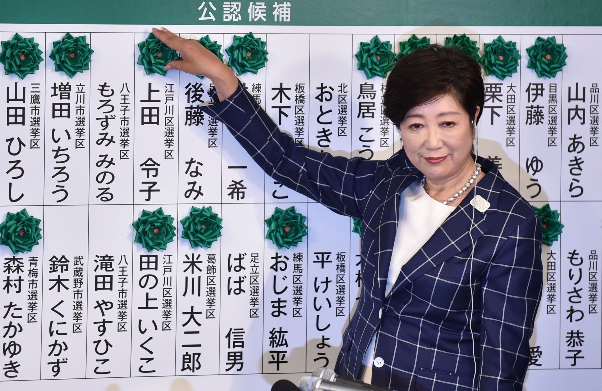 Tokyo Governor Yuriko Koike, who is the current leader of the newly-formed Tomin First no Kai (Tokyo Residents First) party, marks the names of candidates who won a seat in the Tokyo metropolitan assembly election on July 2, 2017. (AFP / KAZUHIRO NOGI)
