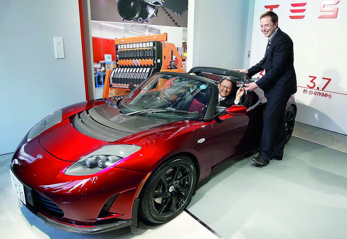 Toyota President Akio Toyoda (left) is presented with the keys to a Tesla Roadster by Tesla CEO Elon Musk in this file picture.