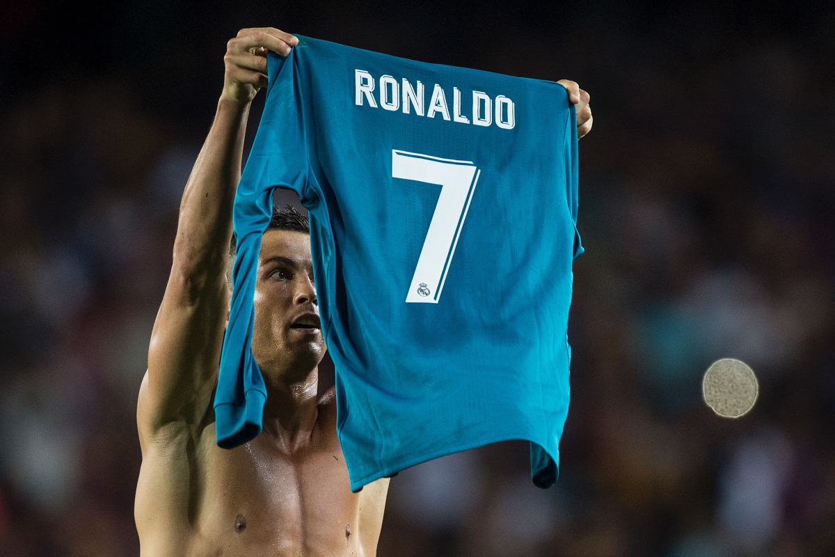 Real Madrid's Portuguese forward Cristiano Ronaldo takes off his jersey to celebrate his goal during the first leg of the Spanish Supercup football match between FC Barcelona and Real Madrid CF at the Camp Nou stadium in Barcelona on August 13, 2017. AFP 