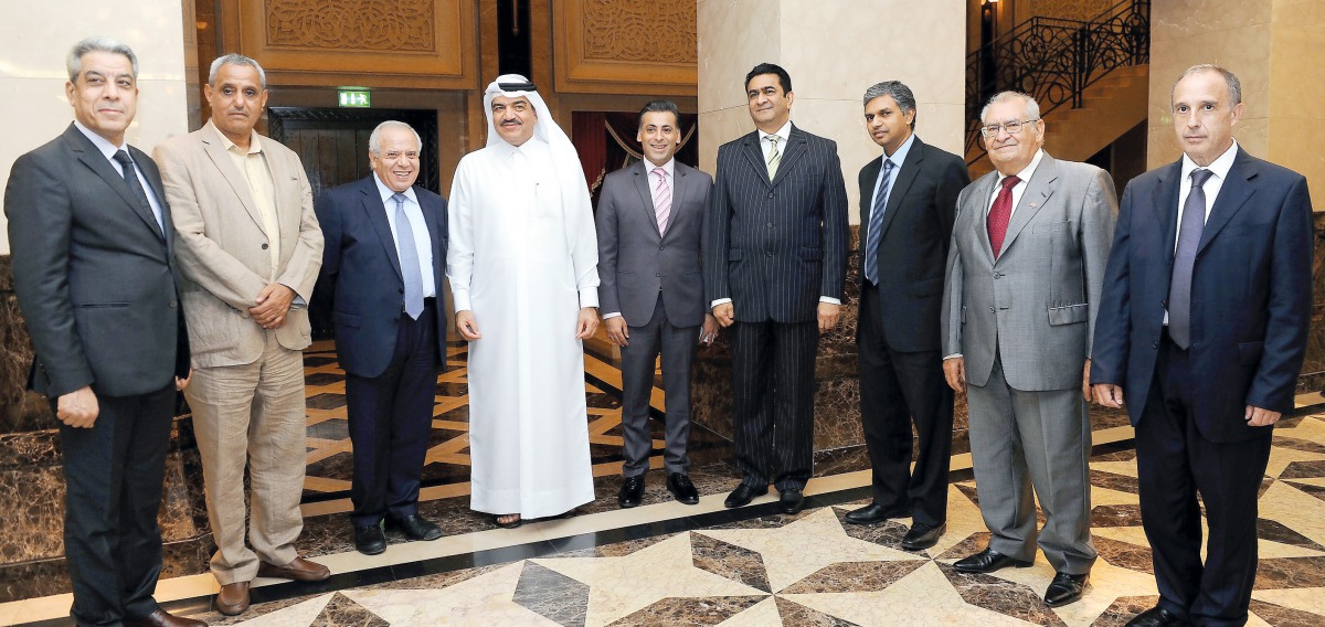 The officials of Qatar Solar Technologies pose for a photograph in front of the signature board bearing ‘Tamim Al Majd’ image. 