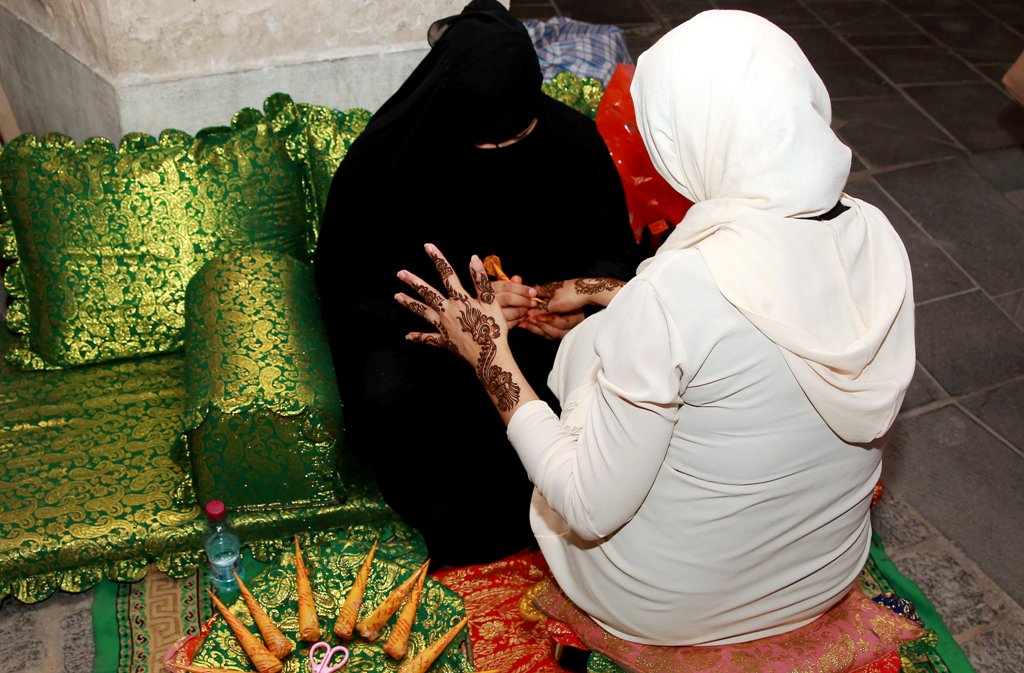 A visitor gets henna patterns applied during her visit to Souq Waqif Doha on the first day of Eid al Adha. Photos by: Qassim Rahmatullah © The Peninsula