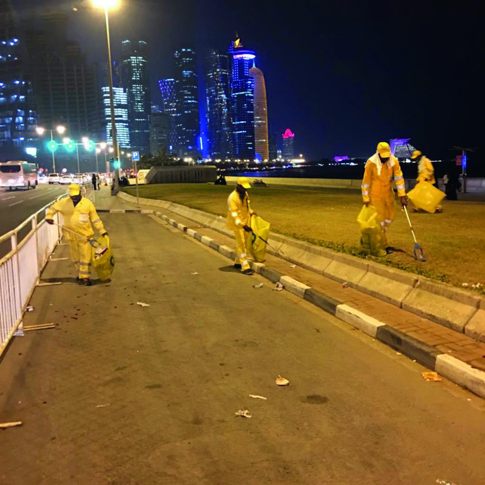Workers cleaning the Corniche.