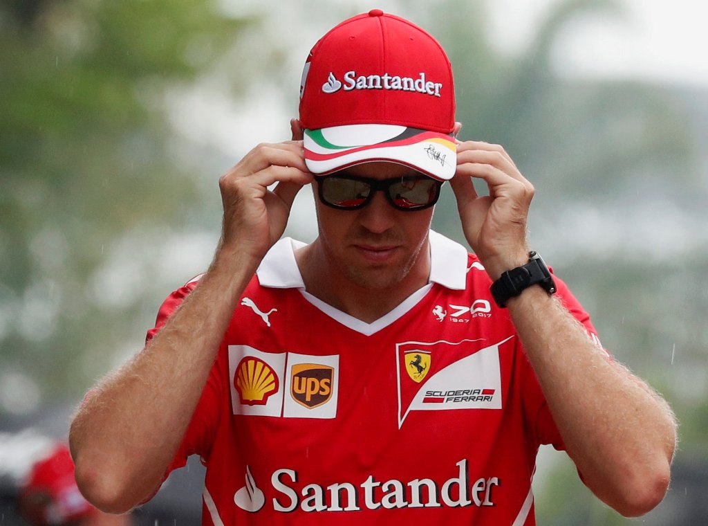 Ferrari's Sebastian Vettel arrives in the paddock. REUTERS/Edgar Su
