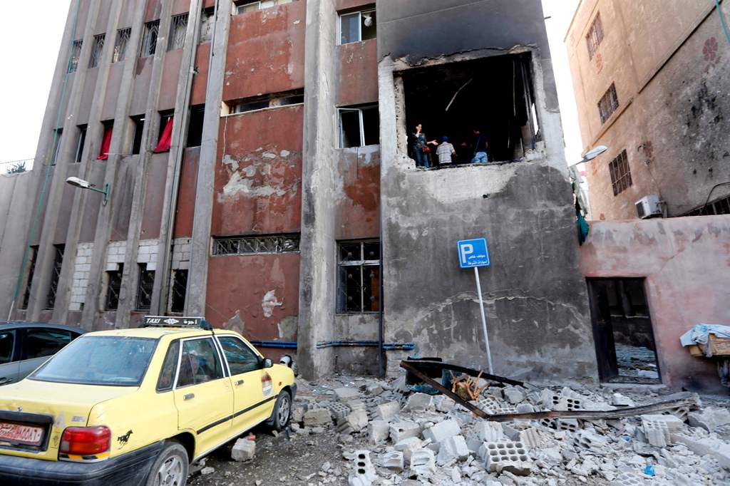 Syrians check the site of a double suicide bomb attack which hit the al-Midan police station in Syria's capital Damascus on October 2, 2017.   AFP / LOUAI BESHARA
