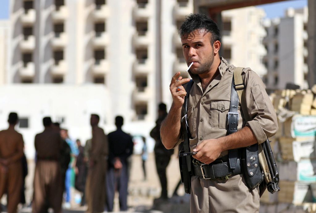 A member of the Iraqi Kurdish forces stands guard at an unfinished housing project where displaced people fleeing violence in the northern Kirkuk province are taking shelter on October 19, 2017 in Arbil, the capital of the autonomous Kurdish region of nor