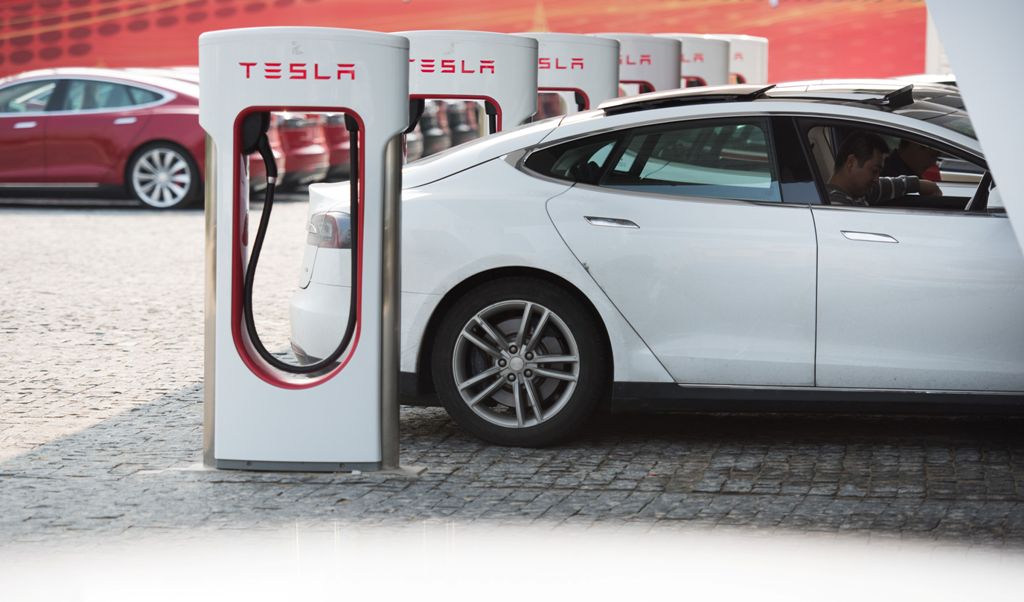 This file photo taken on March 17, 2015 shows a Tesla Model S being charged at a car dealership in Shanghai./ AFP / JOHANNES EISELE