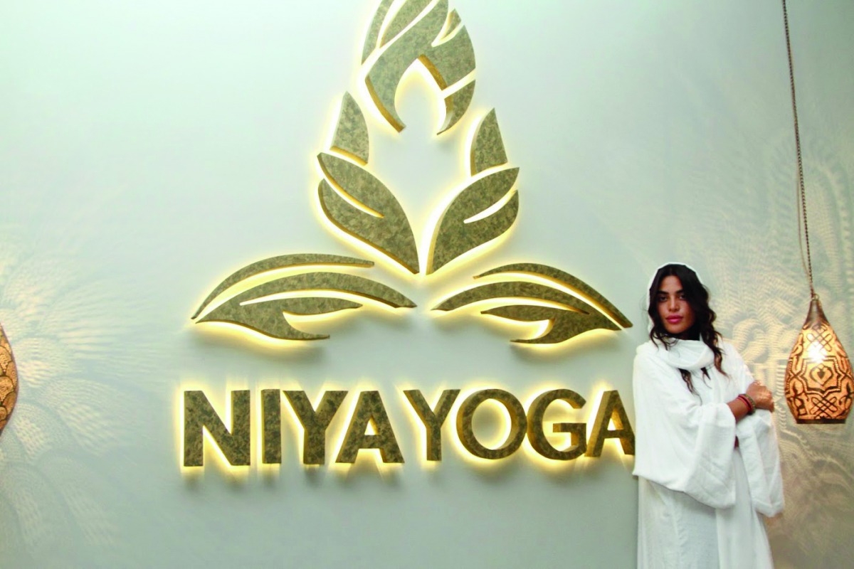 Jawaher Al Fardan poses before the Niya Yoga logo at its studio in Doha.  Niya Yoga is holding a number of ladies-only events that will raise funds for the Breast Cancer Awareness Association in Qatar.