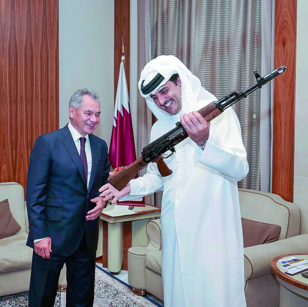 Emir admires a gun as the Russian Defence Minister looks on. 