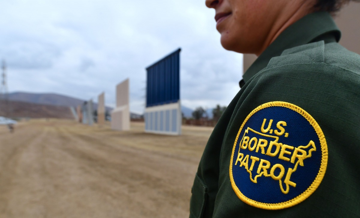 US Border Patrol officer Tekae Michael stands near prototypes of US President Donald Trump's proposed border wall on November 1, 2017 in San Diego, California. AFP / Frederic J Brown