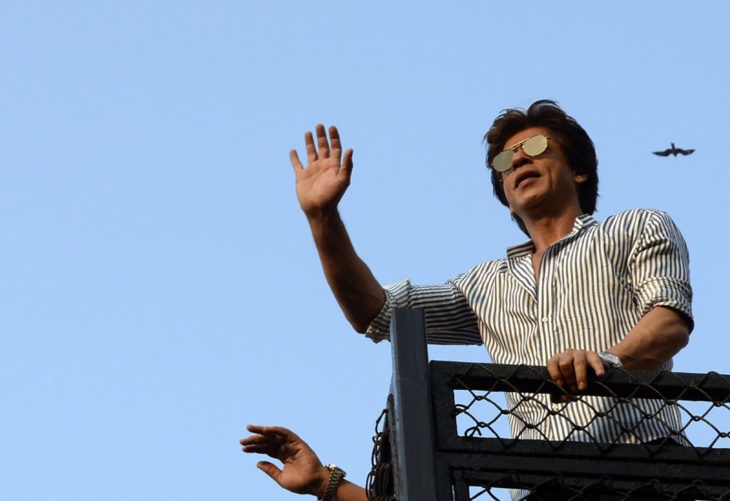 A file photo of  Bollywood actor Shah Rukh Khan seen waving to his fans during celebrations for his 52nd birthday at his home in Mumbai on November 2, 2017. / AFP / Sujit Jaiswal
