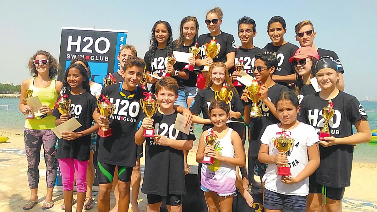 ‘The podium winners at the Swim for a Cause’ open water swimming races organised by Sharq Village and Spa at the Sharq Village & Spa Beach pose for  a group picture.