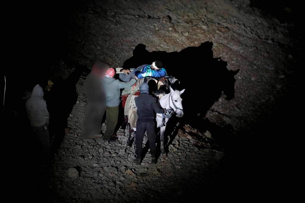 A file photo of a wounded Syrian man being carried on a mule as they approach a meeting point with Israeli soldiers on Mount Hermon in the Israeli-annexed Golan Heights on the border line between Israel and Syria, before being transferred to an Israeli ho