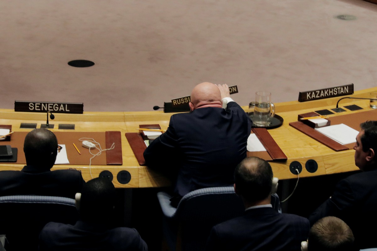 Russian Ambassador to the United Nations Vasily Nebenzya replaces his sign after waving it during a meeting of the U.N. Security Council to vote on a bid to renew an international inquiry into chemical weapons attacks in Syria, during a meeting at the U.N