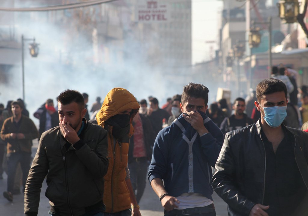 Kurdish protesters run away from tear gaz during a rally against the Kurdistan Regional Government (KRG) in Sulaimaniyah, Iraq December 18, 2017. REUTERS/Stringer. 
