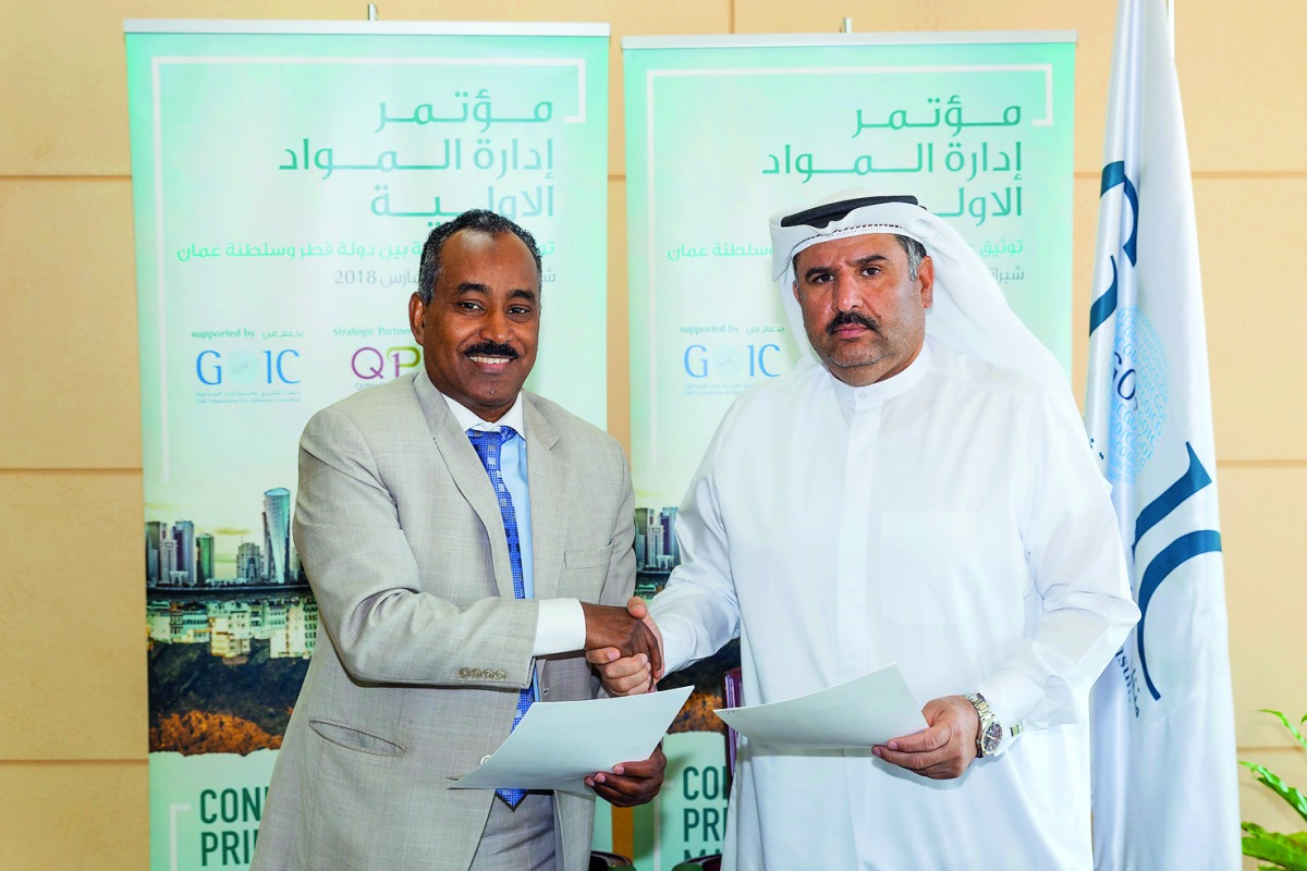 Babeker Osman  and Dr Ali Hamed Al Mulla exchanging documents during the signing ceremony.