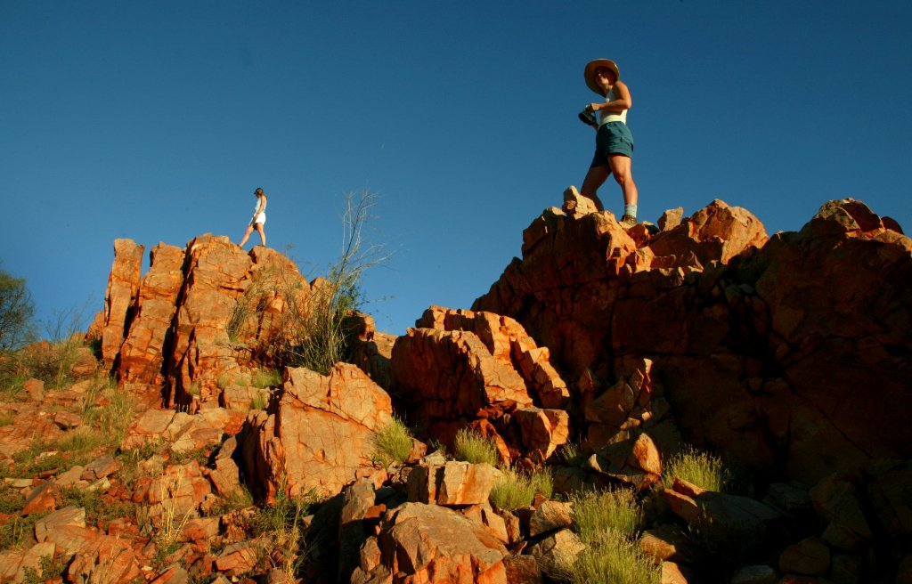 File photo of two tourists watch the setting sun from atop a rocky outcrop in the West MacDonnell Ranges along the Larapinta Trail about 110 kilometres (66 miles) west of the central Australian town of Alice Springs April 18, 2004. REUTERS/Tim Wimborne/Fi