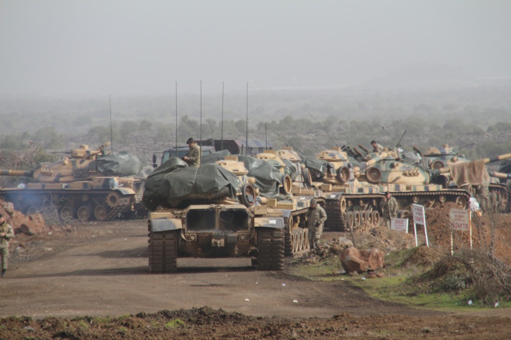 Turkish soldiers are seen on the military vehicles as they move towards to Syrian border as part of the 
