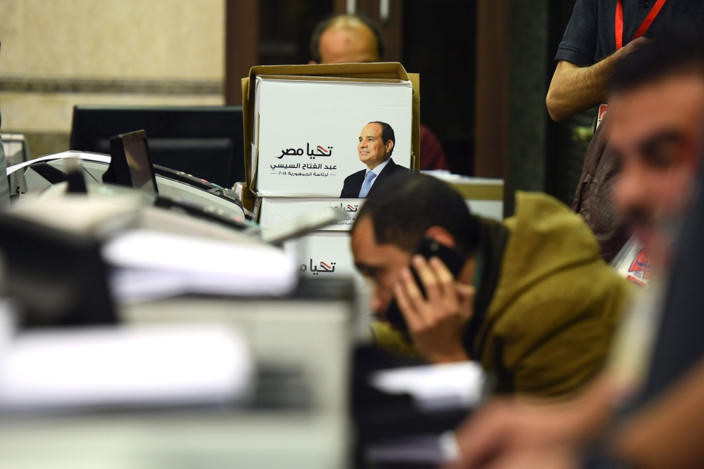 Members of Egyptian President Abdel Fattah al-Sisi presidential campaign staff sift through boxes containing signatures in his support, needed to register for the elections, at the National Election Authority, in Cairo on January 24, 2018.   AFP / MOHAMED