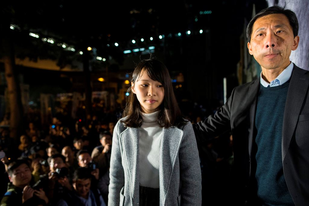Pro-democracy activist Agnes Chow (L) stands on the stage with former lawmaker Edward Yiu Chung-yim (R) during a protest outside Central Government Complex in Hong Kong on January 28, 2018. AFP / Philip Fong