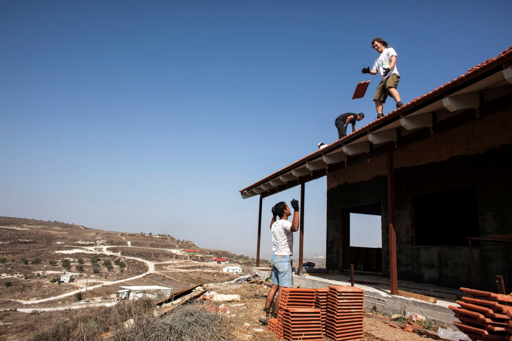 Men work on the roof of a house under construction in the unauthorised Jewish settler outpost of Havat Gilad, south of the West Bank city of Nablus November 5, 2013. Reuters/Nir Elias
