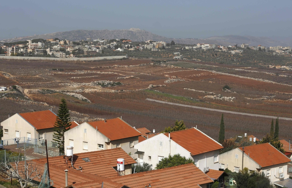 :A picture taken on February 7, 2018 from the Israeli town of Metula shows the Israeli built wall dividing it from the southern Lebanese village of Kafr Kila.  AFP / JALAA MAREY
