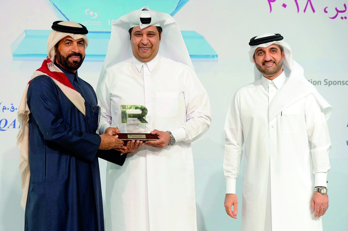 Rashid bin Ali Al Mansoori (left), CEO of QSE giving away the award to QNB official at the 3rd Annual IR Excellence Program,  as Abdul Aziz Al Emadi, Director, Listing Department of QSE, looks on. 
Pic : Abdul Basit
