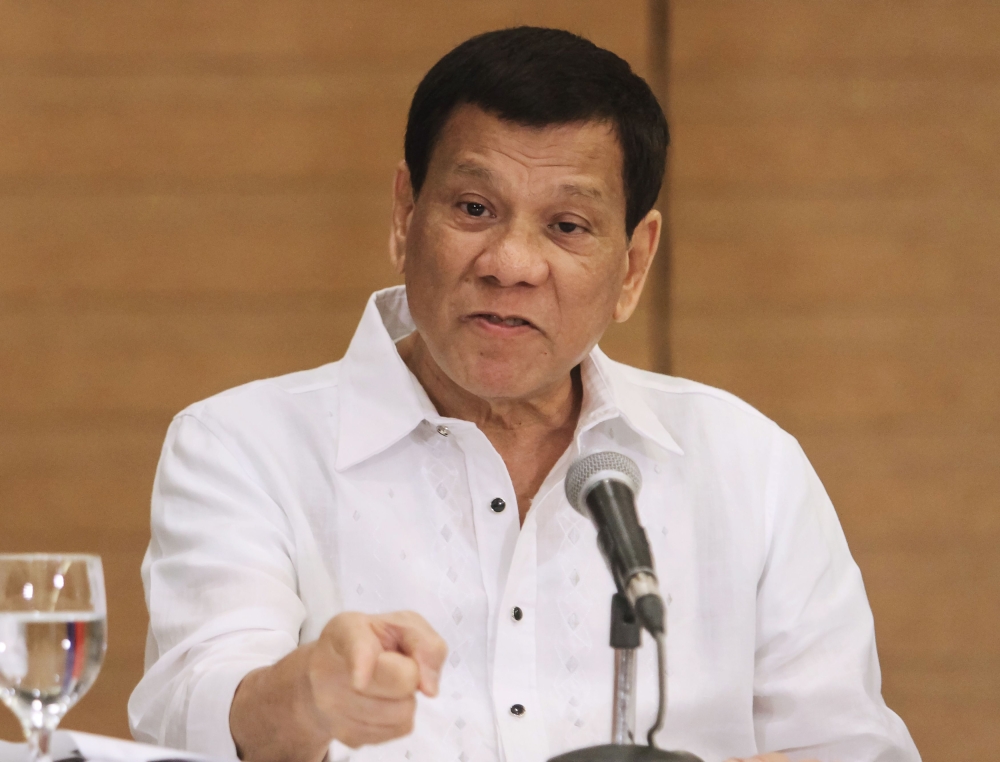 Philippine President Rodrigo Duterte gestures as he speaks during a press conference in Davao City, in the southern island of Mindanao on February 9, 2018. / AFP / -