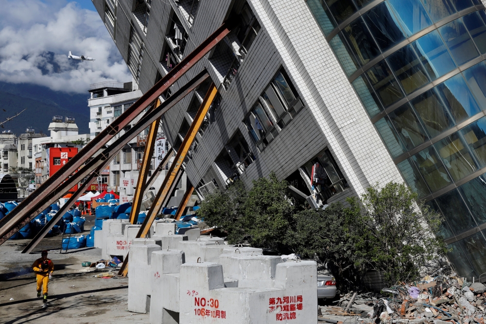 A rescuer rushes to a collapses building after an earthquake hit Hualien, Taiwan February 10, 2018. REUTERS/Tyrone Siu