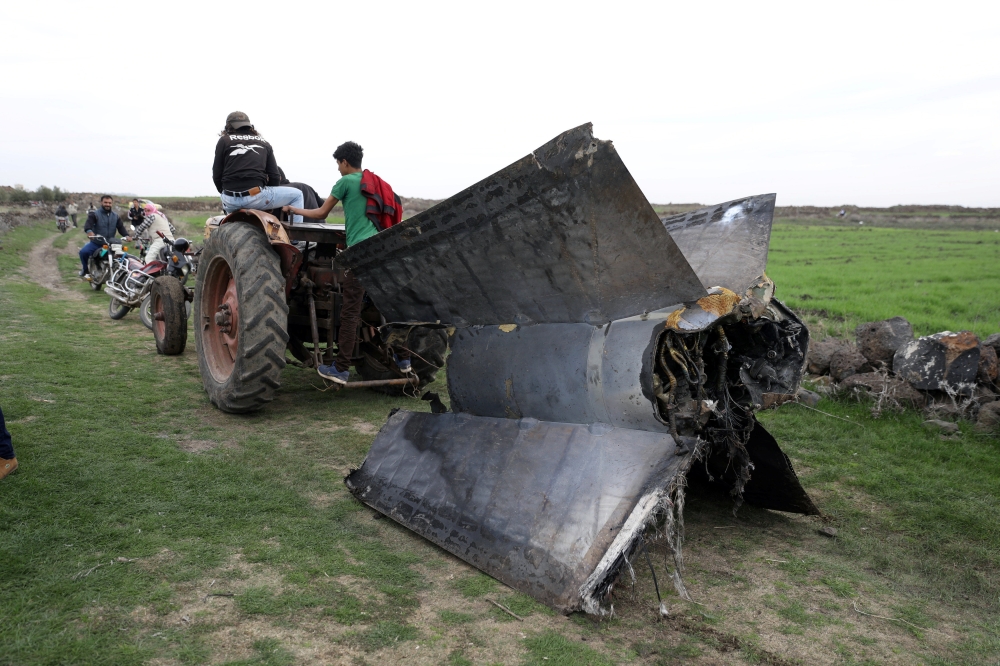 A tractor pulls a part of a missilein Quneitra, Syria February 10, 2018 REUTERS/Alaa al Faqir
