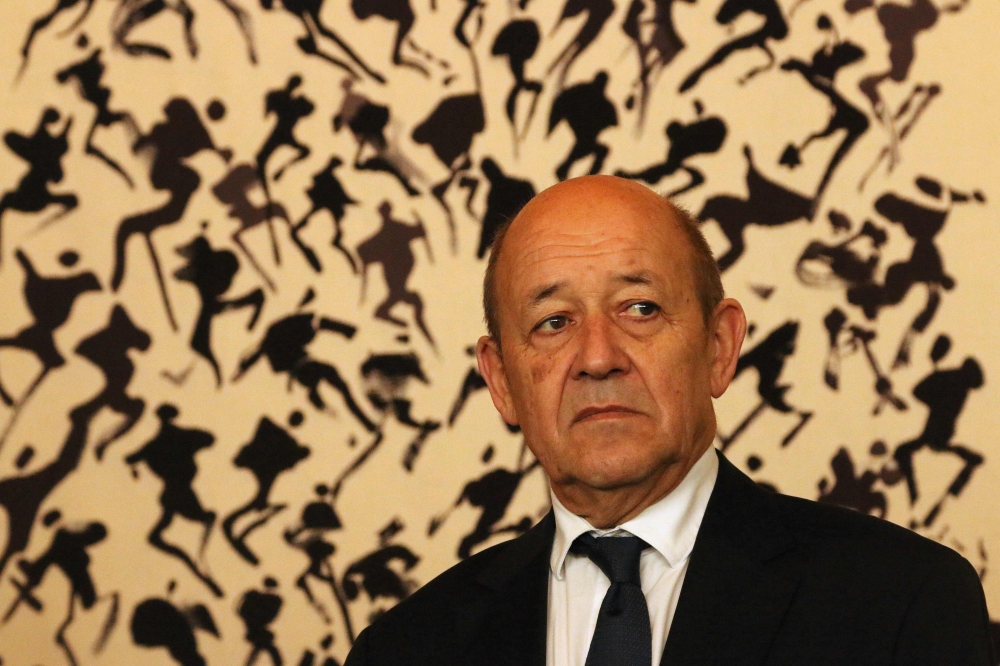 France's Foreign Minister Jean-Yves Le Drian stands in front of artwork by late Korean-born painter Lee Ungno as he attends a ceremony at the French embassy in Seoul on February 11, 2018 to launch the construction of a new embassy building. / AFP / Sebast