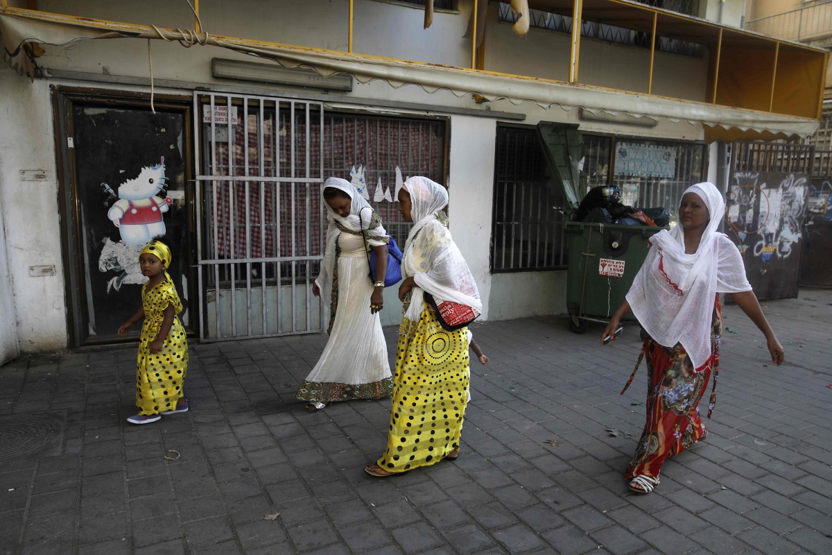 This file photo taken on September 2, 2017 shows Christian African Eritrean migrants walking outside at a makeshift church in southern Tel Aviv.  (AFP / Menahem Kahana)