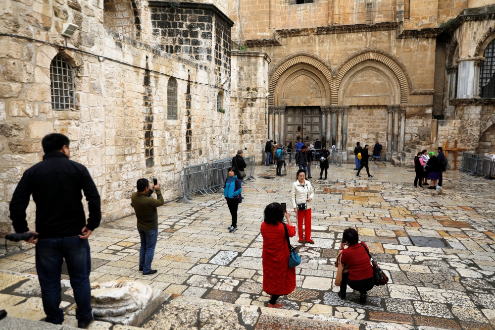 Worshippers and tourists visit the court near the closed doors of the Church of the Holy Sepulchre in Jerusalem's Old City February 26, 2018. Reuters/Ronen Zvulun