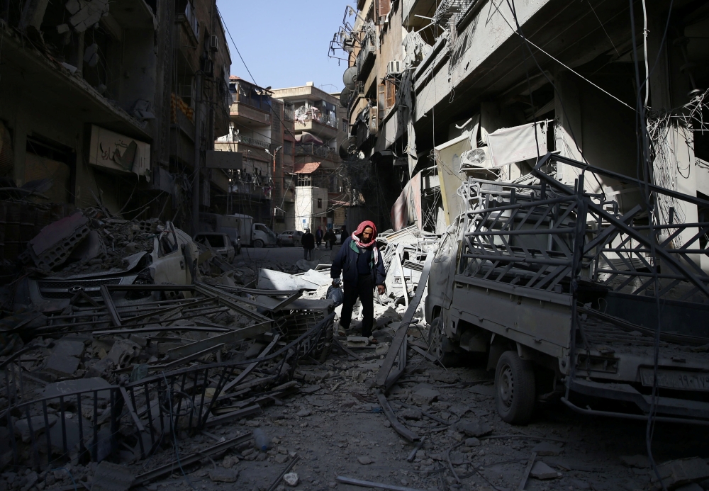 A man walks on the rubble of damaged buildings at the besieged town of Douma, Eastern Ghouta, Damascus, Syria March 5, 2018. REUTERS/Bassam Khabieh