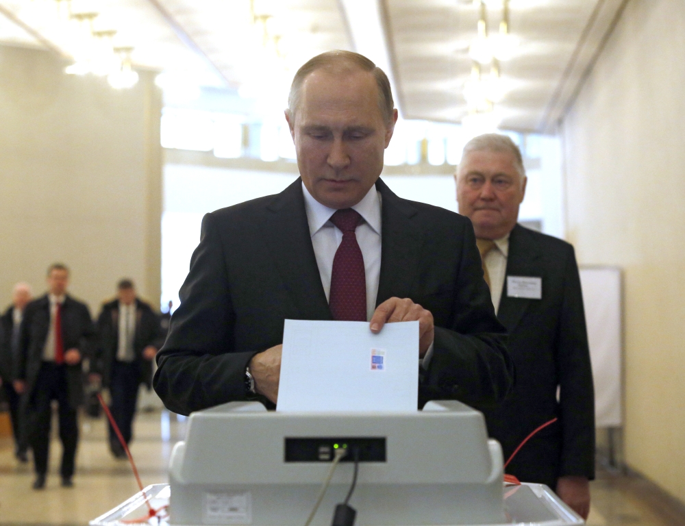 Russian President Vladimir Putin casts his ballot at a polling station during the 2018 Russian presidential election in Moscow, Russia on March 18, 2018.  Nataliy Zemboska - Anadolu 

